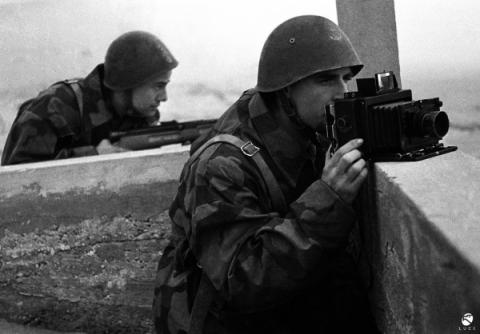Fotografo Luce, 1944. Spesso i fotografi si rappresentavano accanto a fucili e mitragliatrici, paragonando la propria macchina fotografica a un’arma