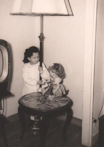 Foto di Elisa Petitta del 1952 che gioca con la bambola accanto alla TV